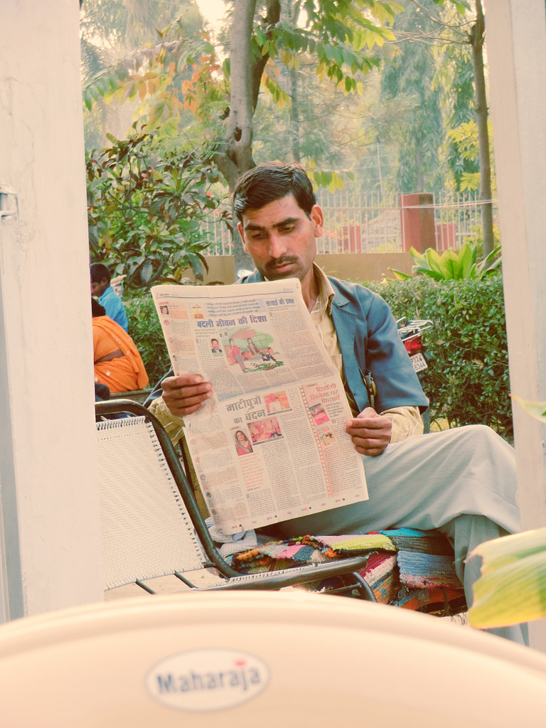 india man reading newspaper